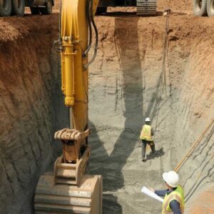 Excavator and Dump Trucks at Construction Excavation Site with Workers